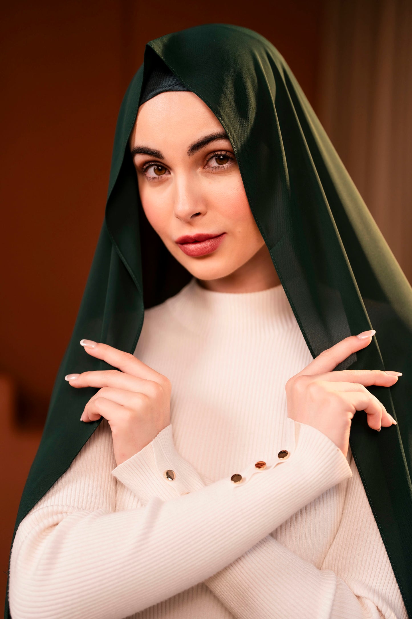 Woman wearing a dark green hijab and a white sweater against a dark background - Forest Green