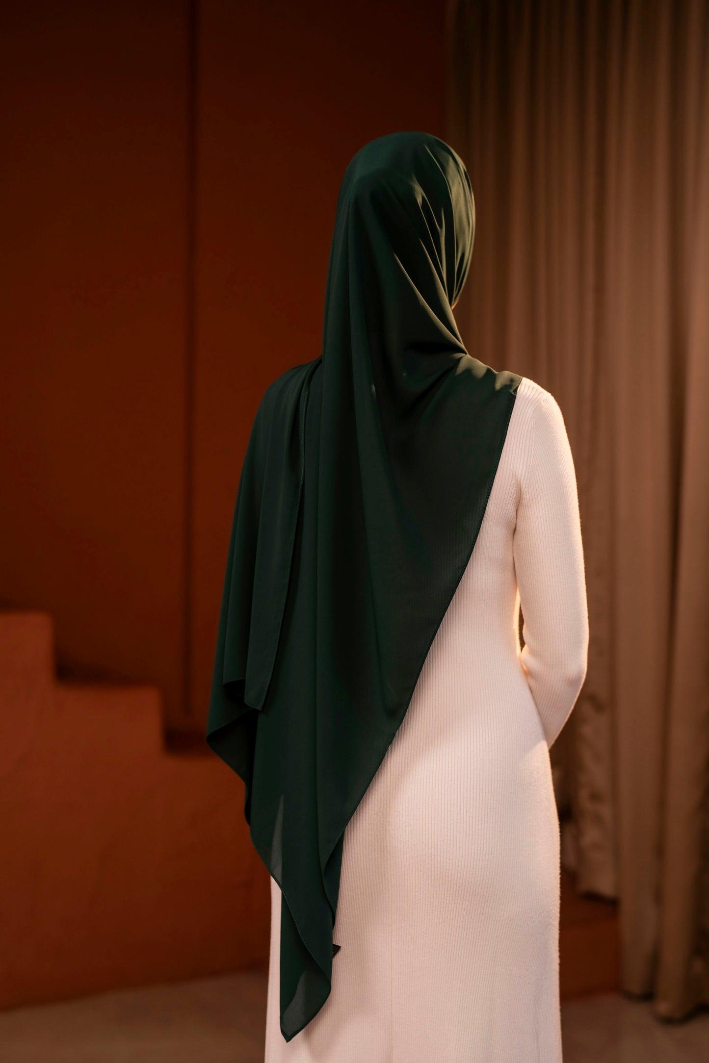 Person wearing a dark green hijab in an indoor setting with neutral walls - Forest Green