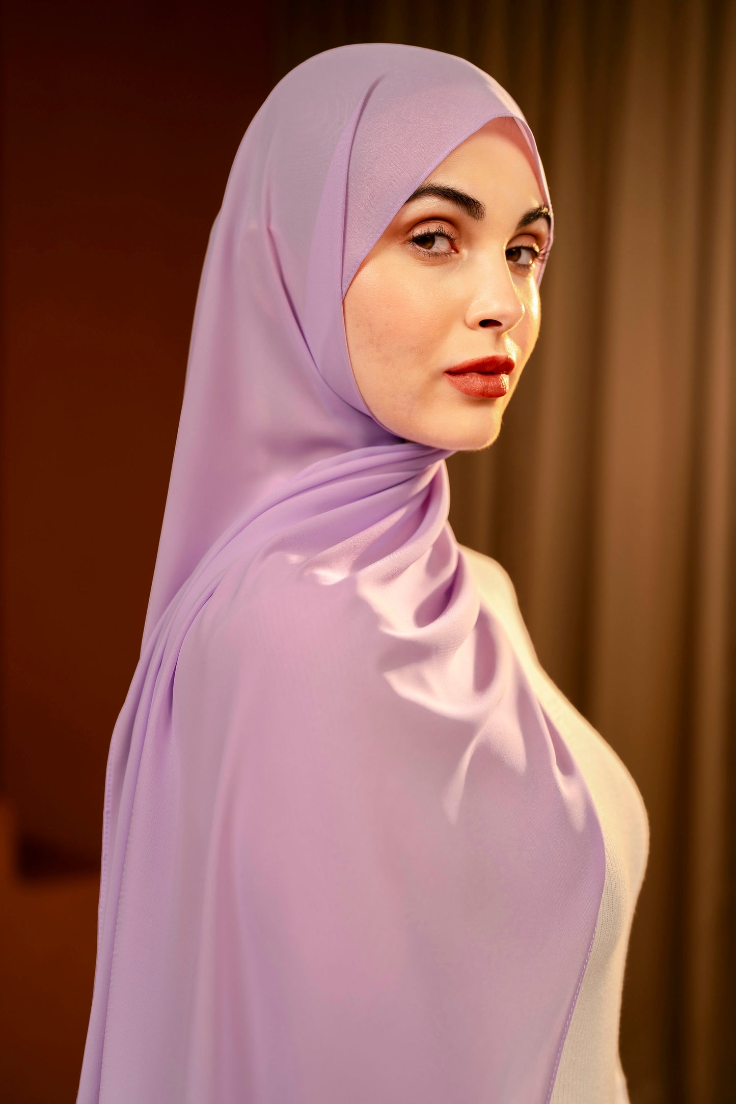 Woman wearing a light purple hijab against a dark sandy background - Lavender