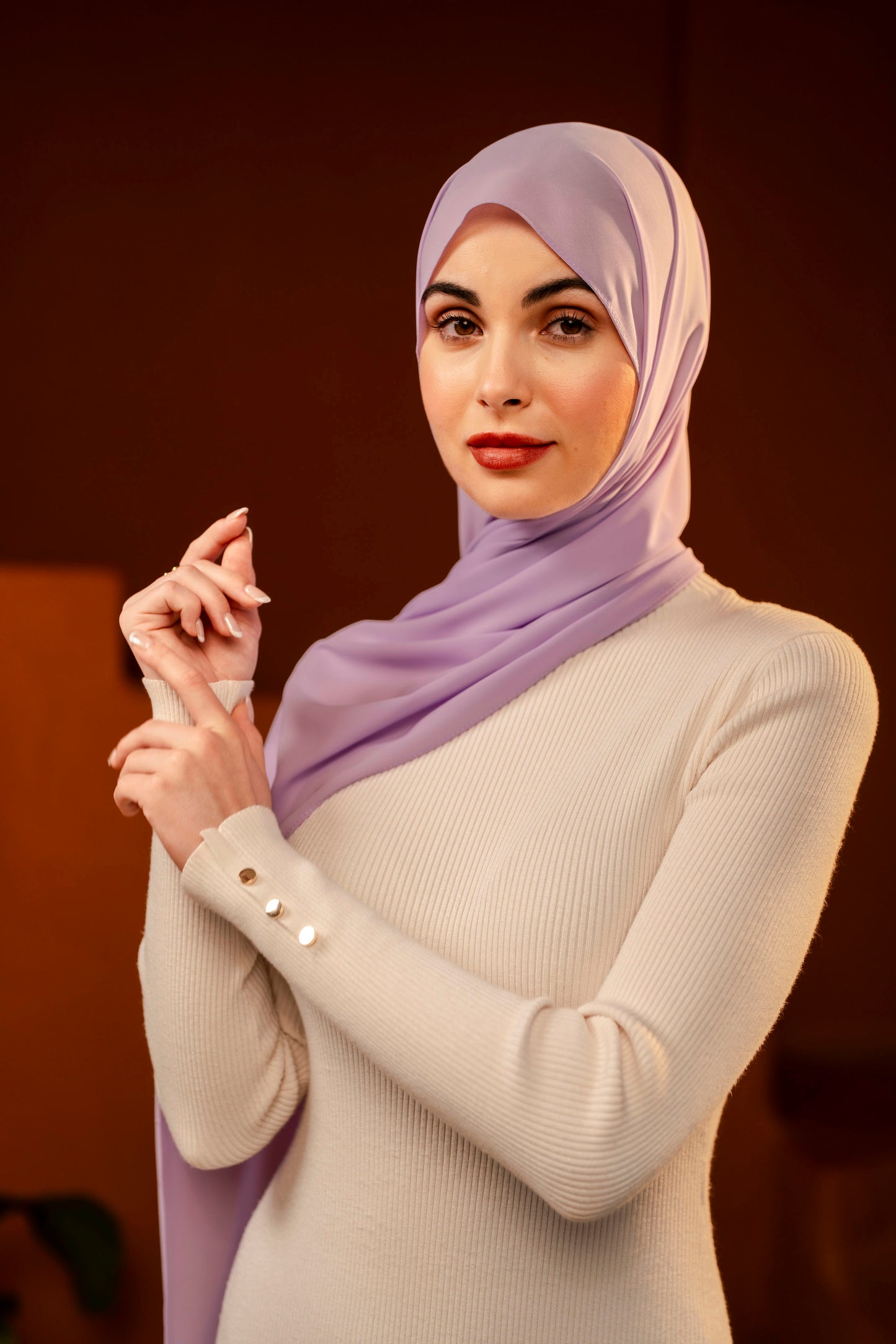 Woman wearing a light purple hijab and beige sweater against a dark background - Lavender