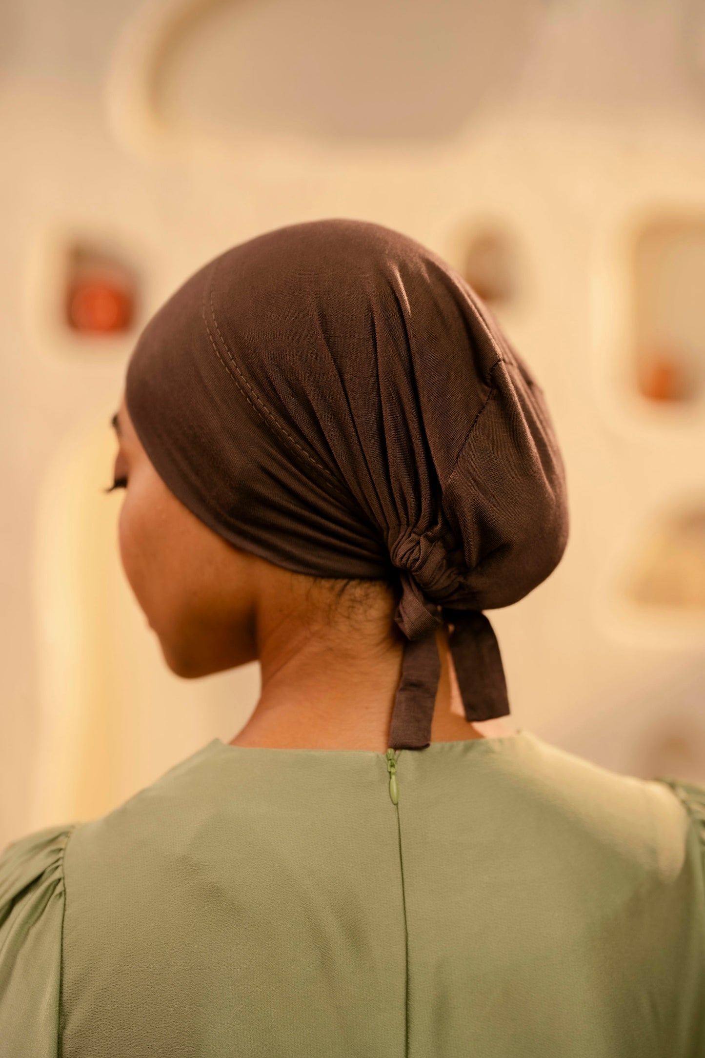 Person wearing a coffee brown headscarf with a blurred background
