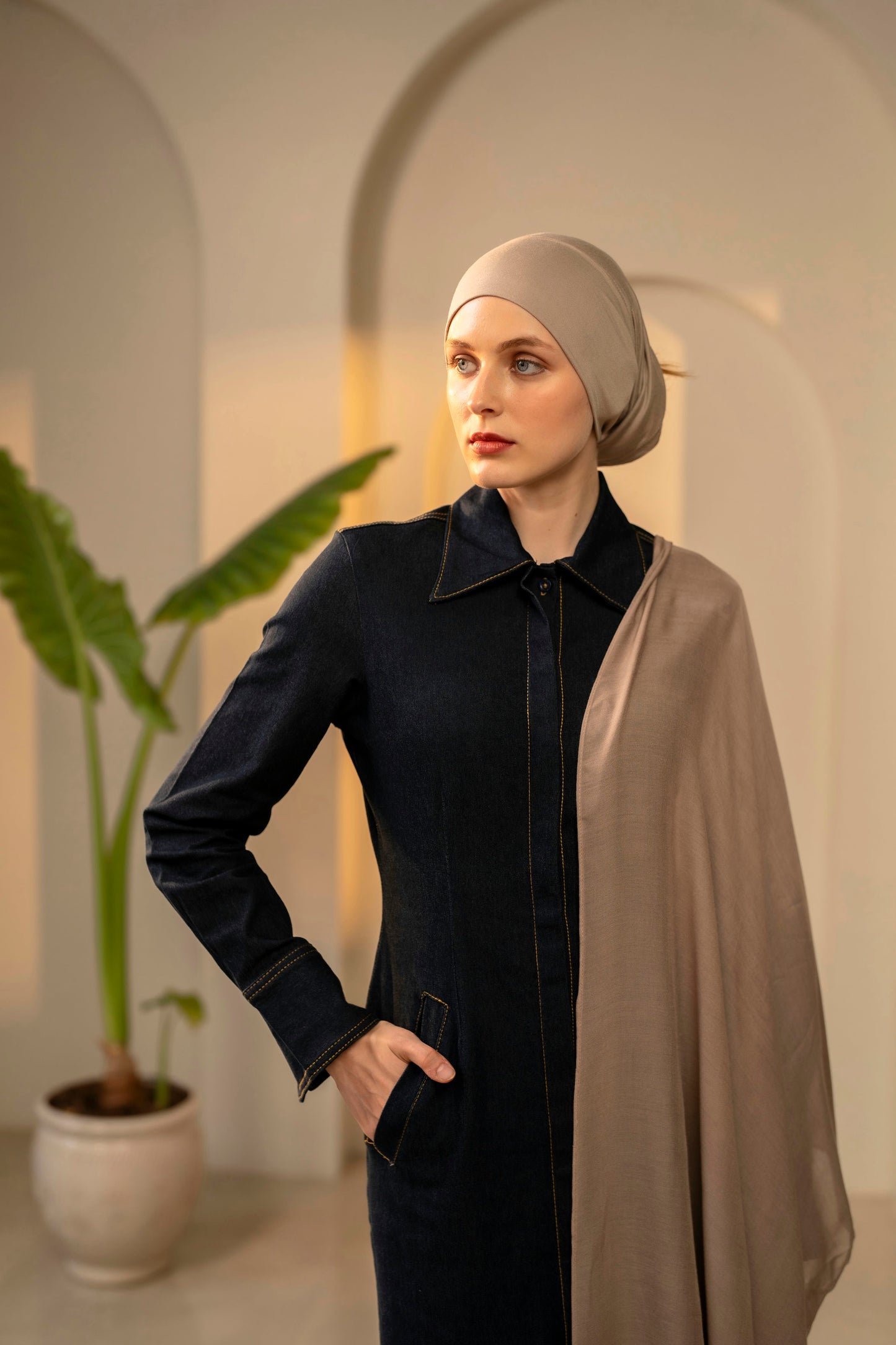 Woman wearing a dark outfit with a beige headscarf and shawl in an indoor setting - mocha