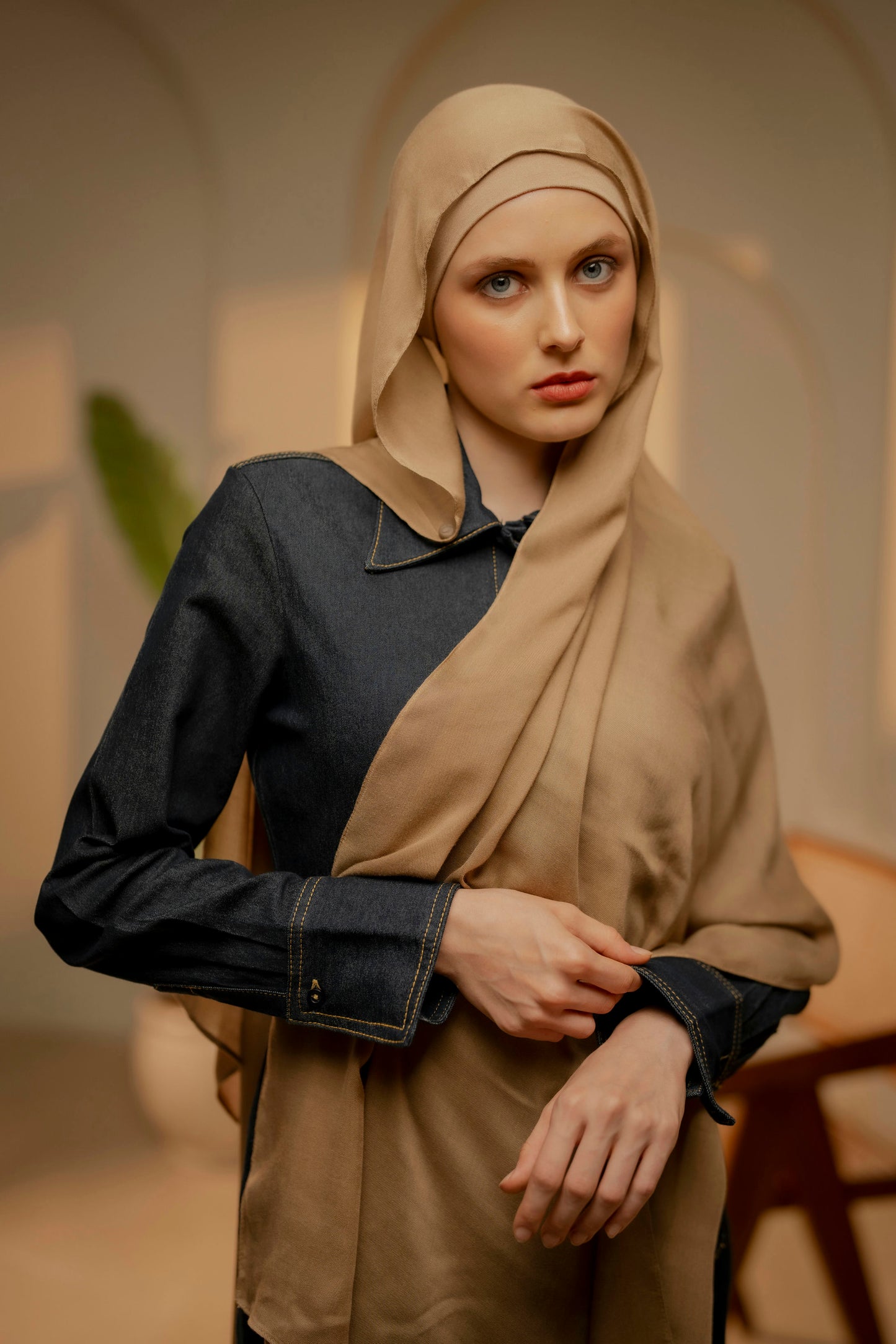 Woman wearing a beige hijab and dark shirt in an indoor setting - caramel