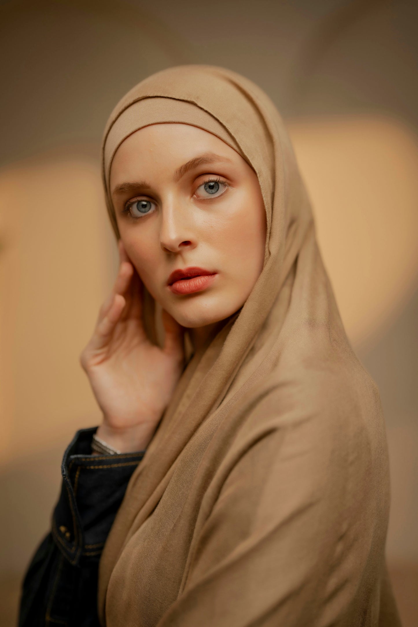 Woman wearing a beige hijab against a blurred background - caramel