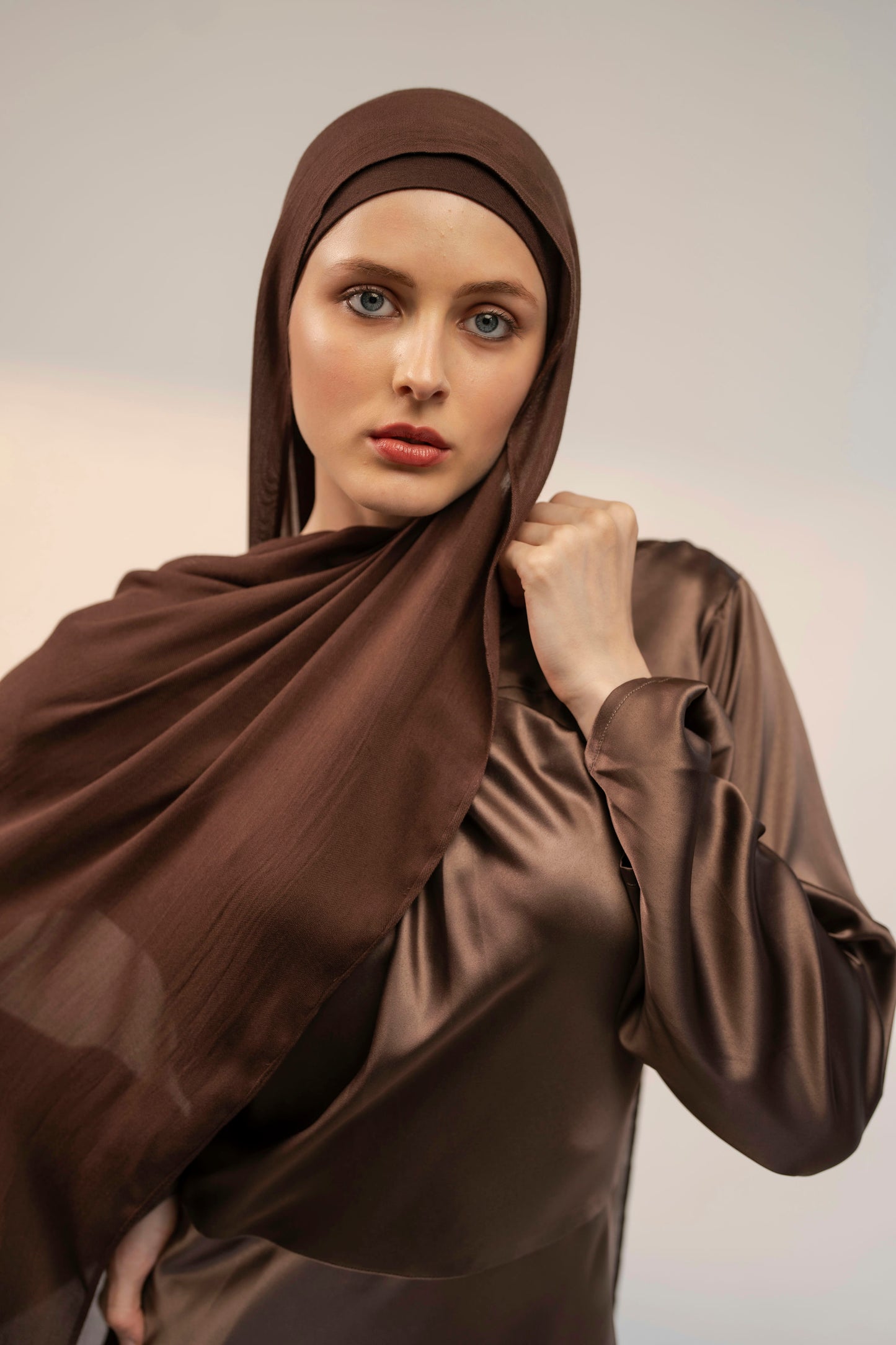 Woman wearing a brown hijab and matching outfit against a plain background - coffee brown