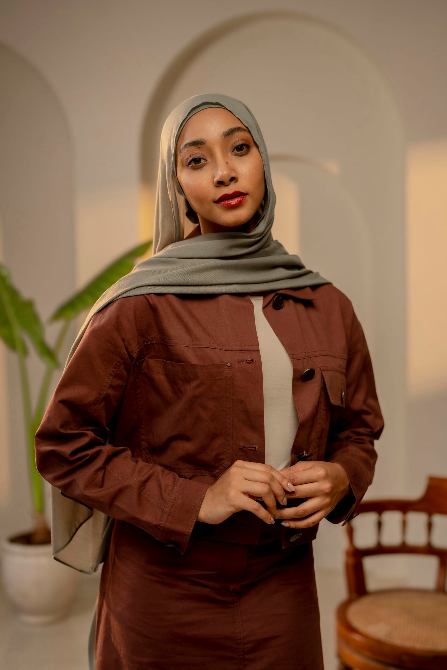 Woman wearing a brown outfit with a hijab in an indoor setting - sage green