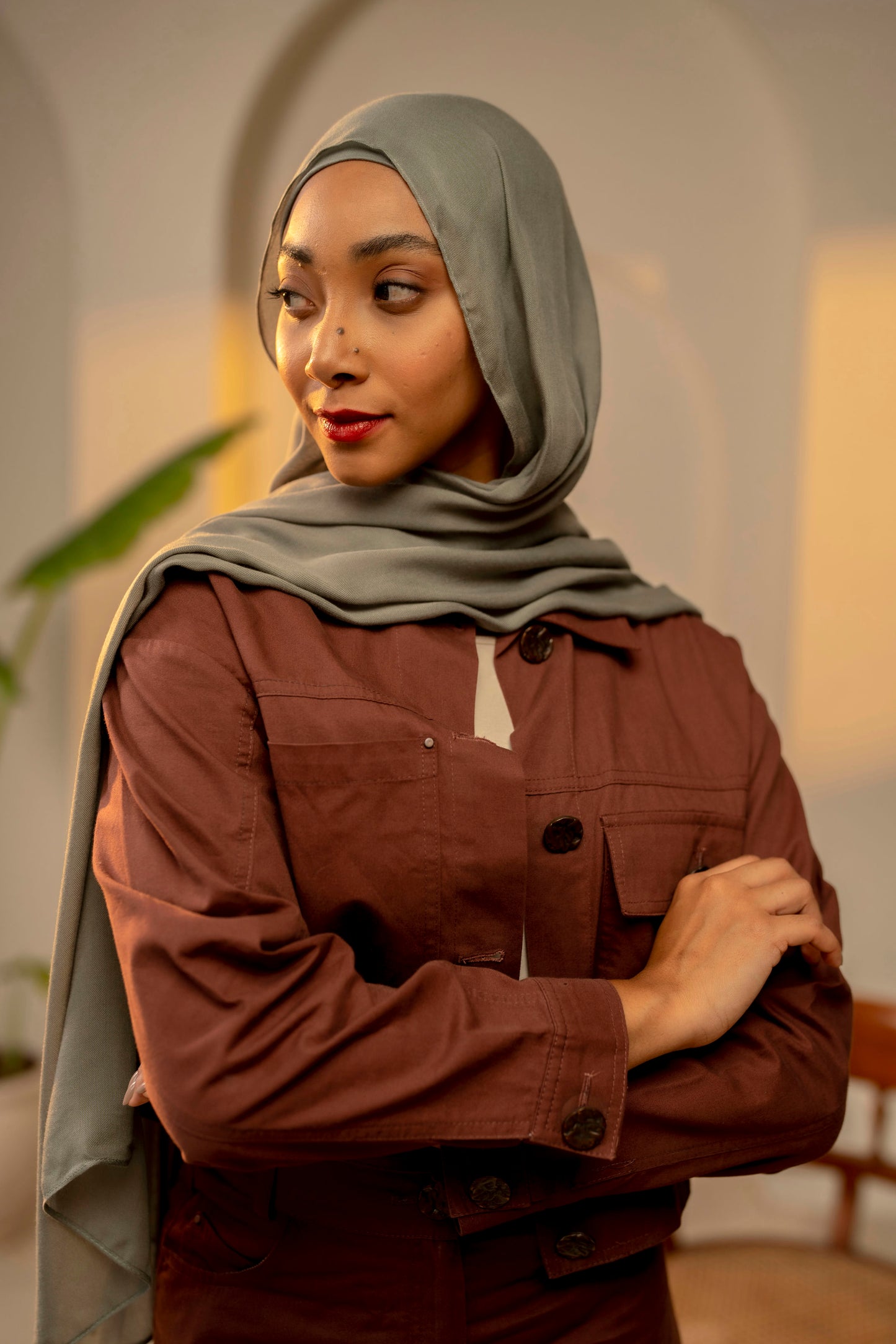 Woman wearing a brown jacket and gray hijab in an indoor setting - sage green colour