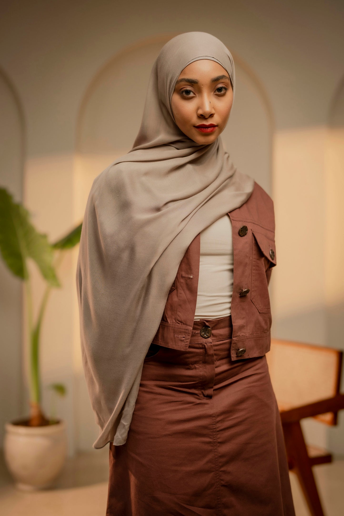 Woman wearing a hijab and brown outfit in an indoor setting - tan