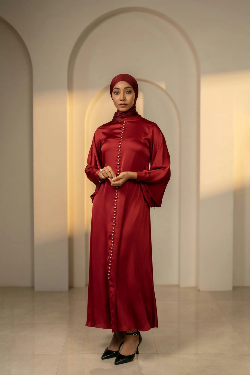Woman wearing a red dress with a hijab in an archway setting