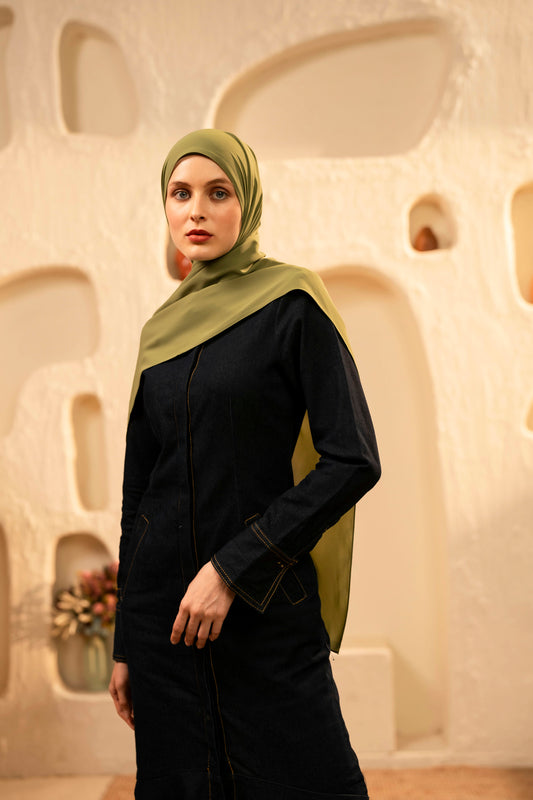 Woman wearing a green hijab and dark outfit against an abstract beige background - Olive Green