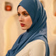 Woman wearing a blue hijab in an airplane cabin - whispering blue
