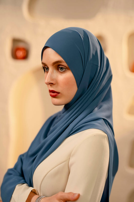 Woman wearing a blue hijab in an airplane cabin - whispering blue