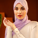 Woman wearing a light purple hijab and white sweater against a warm-toned background - Lavender
