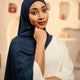 Woman wearing a dark blue hijab and white outfit against a neutral background - Navy