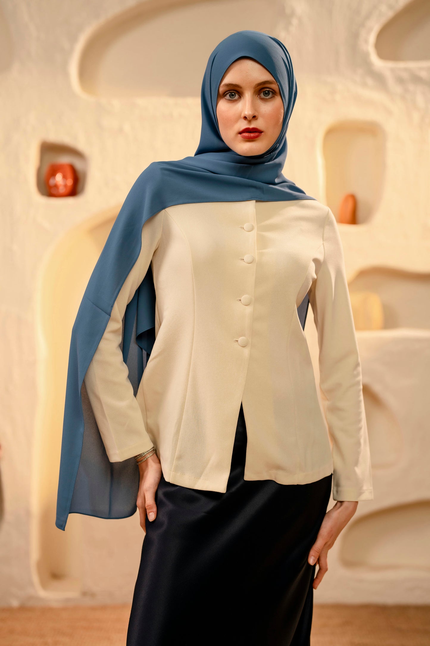 Woman wearing a blue hijab and beige blouse in an architectural setting - whispering blue