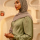 Woman wearing a hijab and green outfit in an indoor setting - khaki