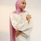 Woman wearing a white outfit and pink hijab against a plain background - cherry blossom