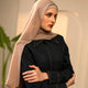 Woman wearing a beige hijab and dark outfit in an indoor setting - mocha