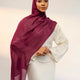 Woman wearing a burgundy hijab and white outfit against a plain background - wine