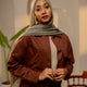 Woman wearing a brown outfit with a hijab in an indoor setting - sage green