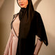 Woman wearing a black hijab and pink dress against a neutral background